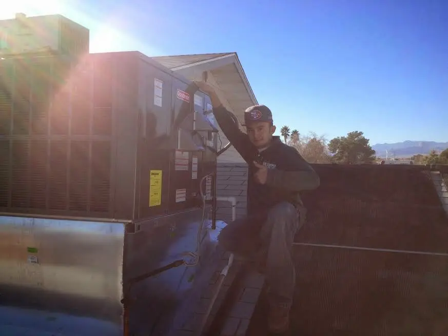 HVAC technician performing AC Tune-Up on a rooftop unit in Pawtucket